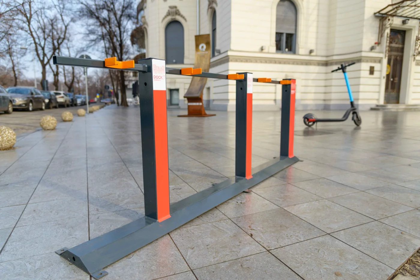 CityDock T1 docking station installed on a city sidewalk in Bucharest, with a scooter parked nearby
